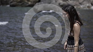 Tilt up view of an european young girl looking at camera and laughing from the seaside.