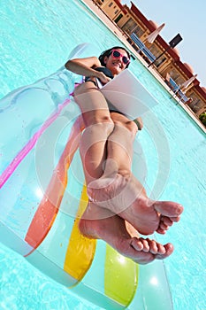Tilt view of happy woman lying on lilo in pool