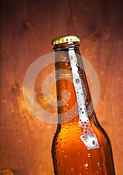 Tilted bottle of fresh beer with drops