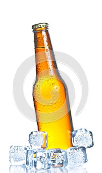 Tilted bottle of fresh beer with ice and drops