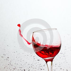 In a tilted glass splashing red wine