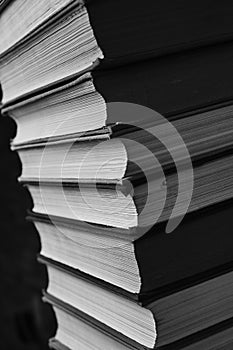 Tilted stacks of books on a black and white photo