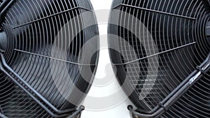 Tilting shot of two large industrial air conditioning condenser fans