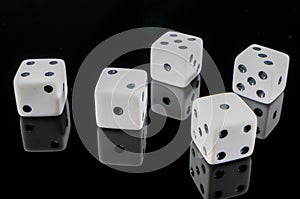 Five dice reflected on black background