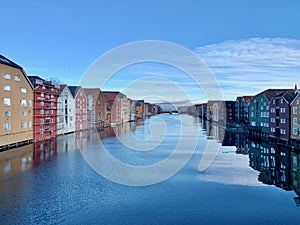 Timber buildings alongside calm water in city of Trondheim, Norway photo