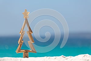 Timber Christmas tree in sand on the beach photo