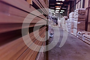 Timber Flooring Factory. Pile of cut wood in factory storage warehouse. Lumber in warehouse