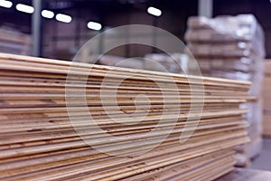 Timber Flooring Factory. Pile of cut wood in factory storage warehouse. Lumber in warehouse