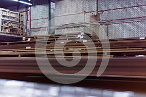 Timber Flooring Factory. Pile of cut wood in factory storage warehouse. Lumber in warehouse