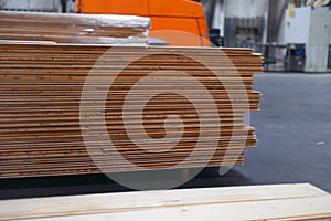 Timber Flooring Factory. Pile of cut wood in factory storage warehouse. Lumber in warehouse