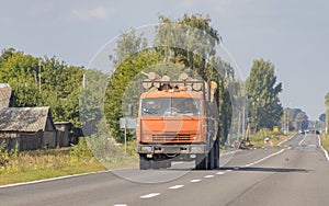 Timber truck with a forest rides on the highway with cargo