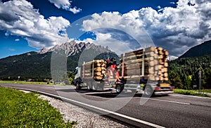 Timber truck rushes down the highway in the background the Alps. photo