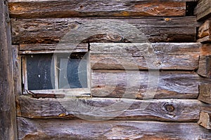 timber wall of an old wooden house with a broken window