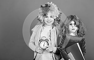 Are we in time. Adorable party goers. Cute children with fancy hair waiting for party time with clock. Little girls