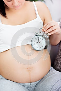Time for baby,pregnant woman with clock