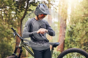 Time, bicycle and man cycling in nature checking his stopwatch in a cardio workout, training and exercise outdoors