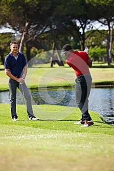 Time for a big swing. two men playing a round of golf together.