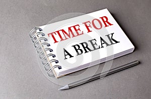 TIME FOR A BREAK word on notebook on grey background