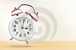 Time change in Austria, spring forward. Summer time concept, over white background. A white alarm clock with a minute