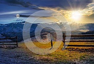 Time change concept. fence on rural field in spring