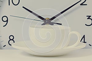 Time for a coffee break, work with coffee cup and clock at ten o clock isolated on white