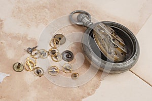 Time concept - broken vintage pocket watch on dirty paper background