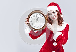 Time Concept and Ideas. Gleeful Red-Haired Santa Helper With Big Round Clock and Showing Time