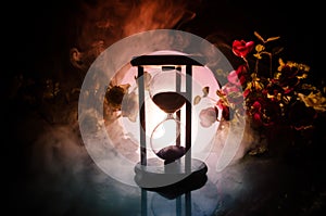 Time concept. Sand passing through the glass bulbs of an hourglass measuring the passing time as it counts down to a deadline. Sil