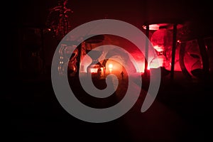 Time concept. Silhouette of a man standing between hourglasses with smoke and lights on a dark background. Surreal decorated