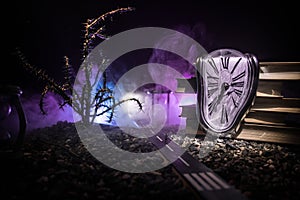 Time concept. Silhouette of a man standing between hourglasses with smoke and lights on a dark background. Surreal decorated