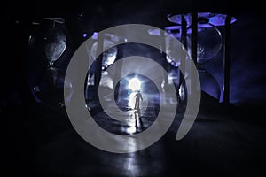 Time concept. Silhouette of a man standing between hourglasses with smoke and lights on a dark background. Surreal decorated