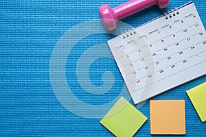 Time for exercising clock, calendar and dumbbell with yoga mat