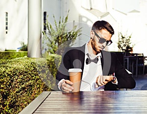 Time. Expectation. Coffee break. man, business man in a business suit and cup of coffee looking at the clock. City cafe