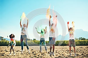 Time flies when you& x27;re having fun. Shot of a group of teenagers having fun with colourful powder at summer camp.