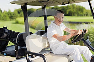 Time for a game of golf. A man in a white suit is riding a white golf cart