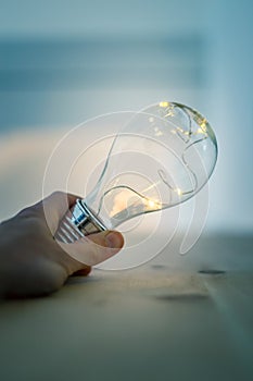 Time for ideas, inspiration and invention: Hands are holding a LED lightbulb