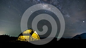 Time laps of milky way moving across mountain above camping tent