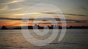 Time laps of the seascape with a view of the silhouettes of the ship and the city