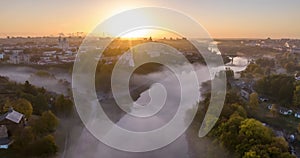 time lapse 4k over morning river with mist and fog overlooking old medieval castle and city with historic buildings