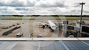 Time lapse of airplane docking operation, plane take off at airport runway. Solar cell panel sustainable energy.