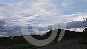 TIME LAPSE - Asphalt road to hill and beautiful dramatic clouds