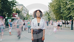 Time lapse of attractive African American girl standing alone in city street