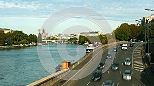 Time lapse of car traffic on the Seine river embankment in Paris and distant Notre-Dame Cathedral, France