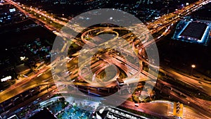 Time-lapse of car traffic transport on multiple lane highway or winding road expressway in Asia city at night, drone aerial view