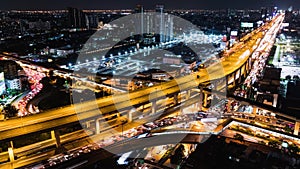 Time-lapse of car traffic transportation on highway, road intersection, sky train railway, with under construction site at night
