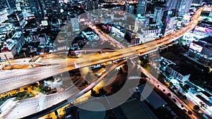 Time-lapse of car traffic transportation on highway road, toll gate at night. Cityscape view with construction crane on building