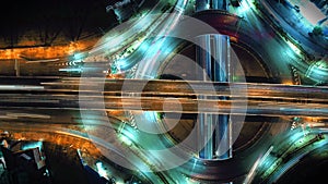 Time-lapse of car traffic transportation on road at junction intersection, 4K. Aerial view of road interchange or highway intersec