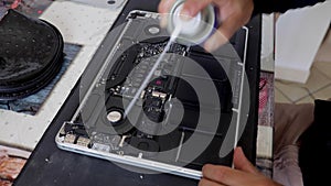 Time lapse: caucasian technician opens and repairs or cleans a laptop. Top view