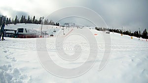 Time lapse of chair lifts and skiiers with snowboarders riding down the hill at a ski resort Ruka in Finland