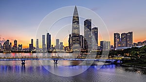 Time-lapse city skyline buildings and water surface at sunset in Shenzhen Talent Park